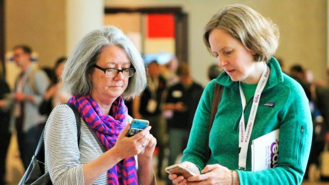 SXSW EDU 2017 attendees checking the mobile app. Photo by Nicole Burton.